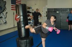 a woman is practicing boxing in a gym