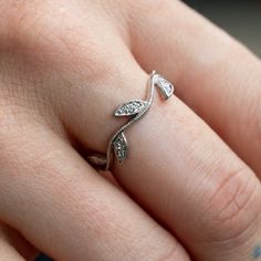 a close up of a person's hand with a ring on their finger,