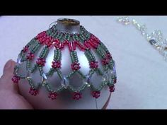 a hand is holding a beaded ornament