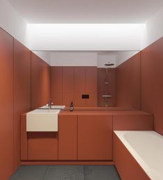 a bathroom with an orange wall and white bathtub next to a sink in the corner