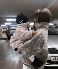 a young boy is hugging an older man in a parking garage