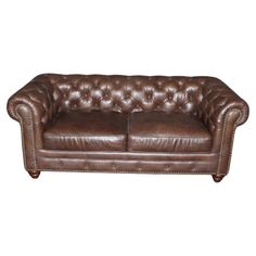 a brown leather couch sitting on top of a white floor