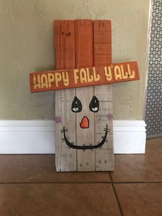 a wooden sign that says happy fall y'all with a scarecrow face on it