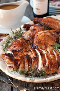 sliced chicken on a plate with rosemary sprigs