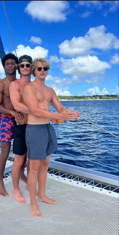 three men standing on the deck of a boat posing for a photo with their arms around each other