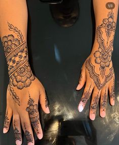 two hands with henna tattoos on them