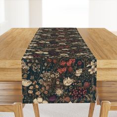 a wooden table topped with a floral print table runner