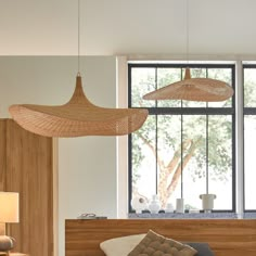 two lamps hanging from the ceiling above a bed in a room with wood paneling