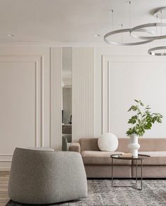 an elegant living room with white walls and beige furniture, along with a large rug on the floor