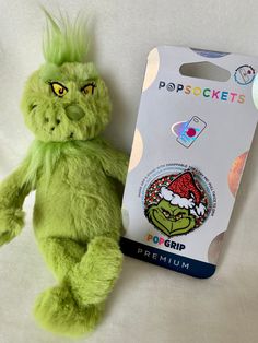 a green stuffed animal next to a package