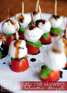 small appetizers with toothpicks and tomatoes on a white plate