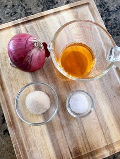 an onion, garlic and seasoning on a cutting board