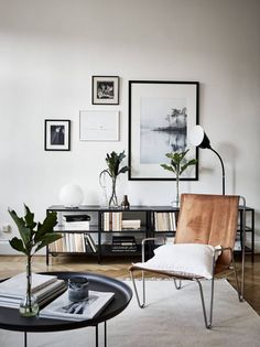 a living room with pictures on the wall and a chair next to a coffee table