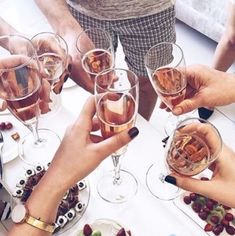 several people toasting with wine glasses on a table