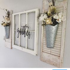 two vases with flowers are hanging on the wall next to an old window frame