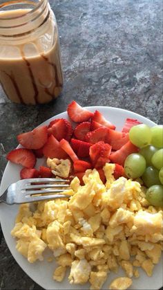 a white plate topped with eggs and fruit next to a jar of chocolate milk