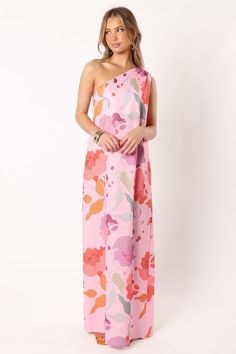 a woman wearing a pink and orange floral print one shoulder dress with an asymmetrical neckline