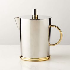 a silver and gold coffee pot on a white table