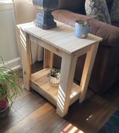 a wooden table sitting on top of a hard wood floor next to a brown couch