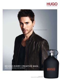 a man is wearing a leather jacket and standing in front of a black bottle with the words, behind every creative man