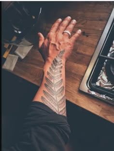 a person's hand with a tattoo on it next to a stove top oven