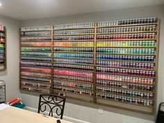 a room filled with lots of different colored bottles on the wall next to a table