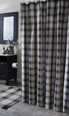 a black and white checkered shower curtain next to a dresser with a mirror on it