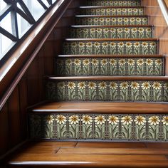 some stairs with flowers painted on them and wooden handrails in front of the railing