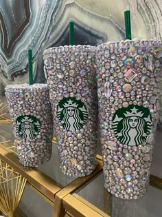 three glitter starbucks cups sitting next to each other