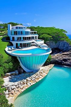 an aerial view of a house with a pool in the foreground and ocean behind it