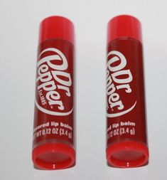 two red lip bales sitting next to each other on top of a white table