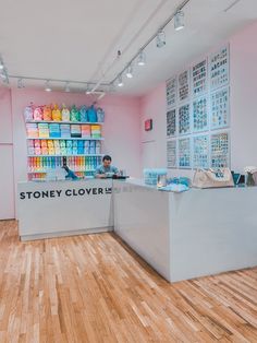 a store with wooden floors and pink walls, filled with shelves full of colorful items