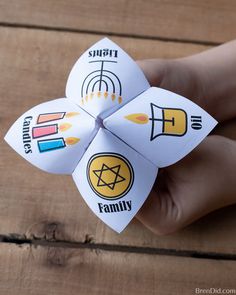 a hand holding a paper flower with stickers on it's petals that read smart family