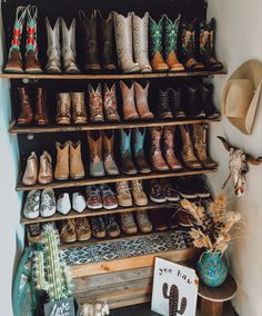 there are many pairs of cowboy boots on the shelf next to each other in this room