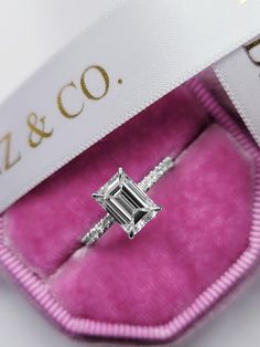 an engagement ring in a pink velvet case with the name liz & co written on it