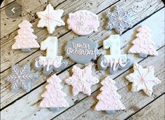 decorated cookies with frosting and decorations on a wooden surface, including one for the first time