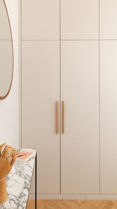 a marble counter top sitting next to a white cabinet with wooden handles and knobs