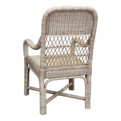 a white wicker chair with an armrest and seat cushion on the back side