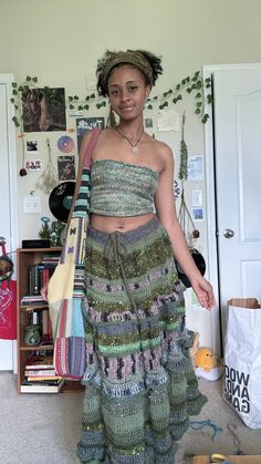 a woman standing in a room wearing a dress made out of knits and crochet