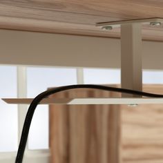 a close up of a black cord connected to a light fixture on a wooden ceiling