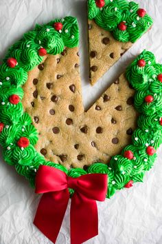 a christmas cookie cake with green frosting and red bows on it's side