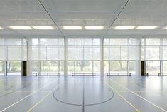 an empty basketball court with lots of windows