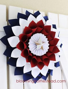 a red, white and blue paper flower is hanging on the wall