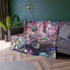 the couch is covered with colorful mushrooms on purple and blue background, as well as a cross - stitch design