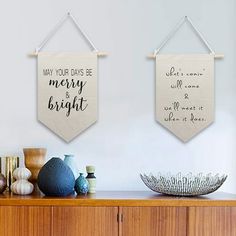 two wall hangings with words on them