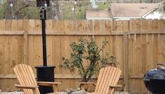 two adiron chairs sitting next to each other in front of a bbq grill