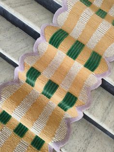 close up view of the side of a bench with green and yellow stripes