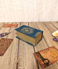 an open book sitting on top of a wooden table next to other books and items