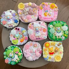 there are many decorated cupcakes on the plate with flowers and animals in them