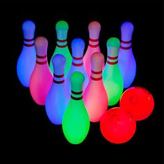 glowing bowling pins and balls are shown in the dark with neon colors on them,